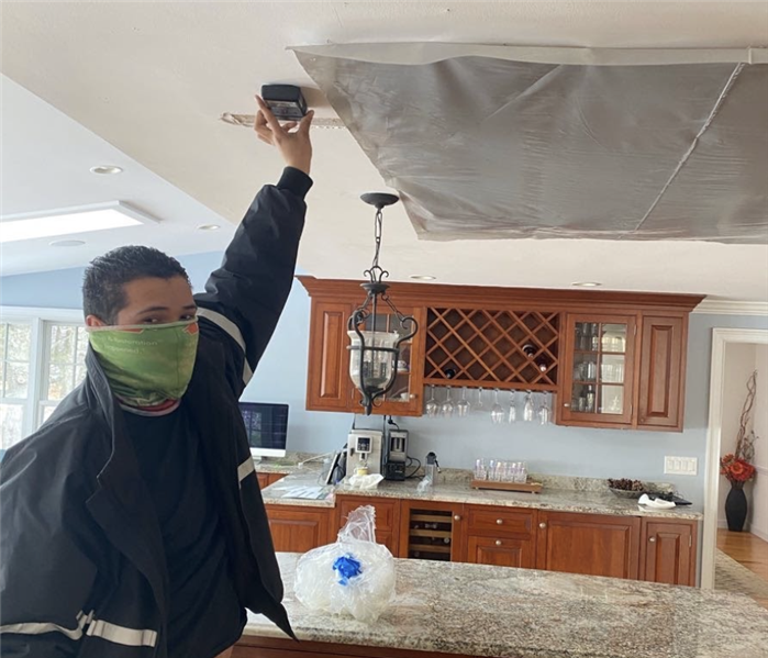 man holding device to ceiling 